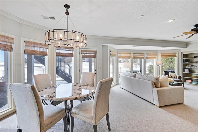 dining room featuring crown molding, ceiling fan with notable chandelier, light carpet, and a textured ceiling