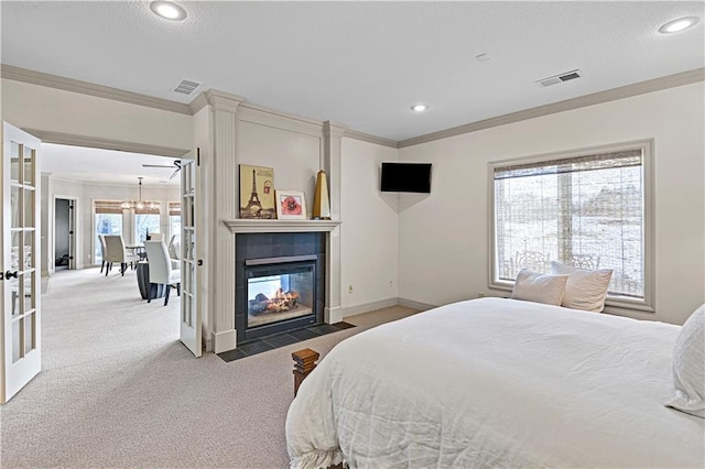 carpeted bedroom featuring multiple windows, crown molding, a multi sided fireplace, and french doors