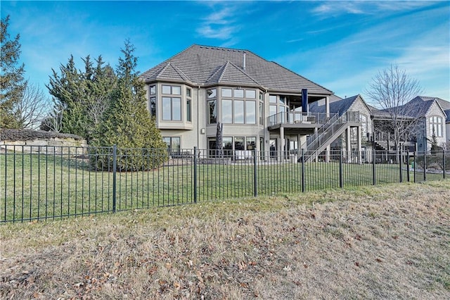 rear view of house with a deck and a lawn