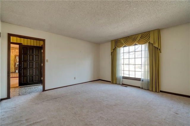 unfurnished room with baseboards, carpet, and a textured ceiling