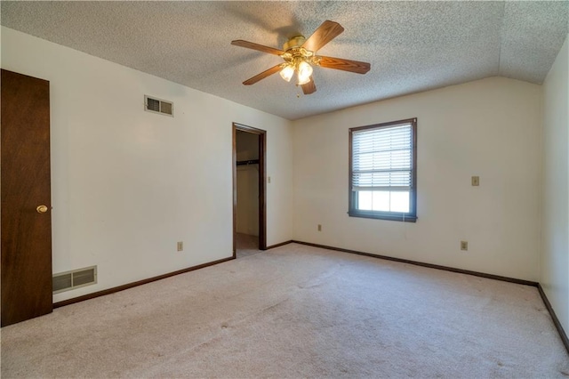 unfurnished bedroom with baseboards, light colored carpet, visible vents, and a textured ceiling