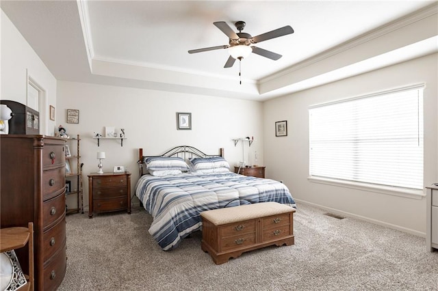 bedroom featuring ceiling fan, light colored carpet, and a tray ceiling