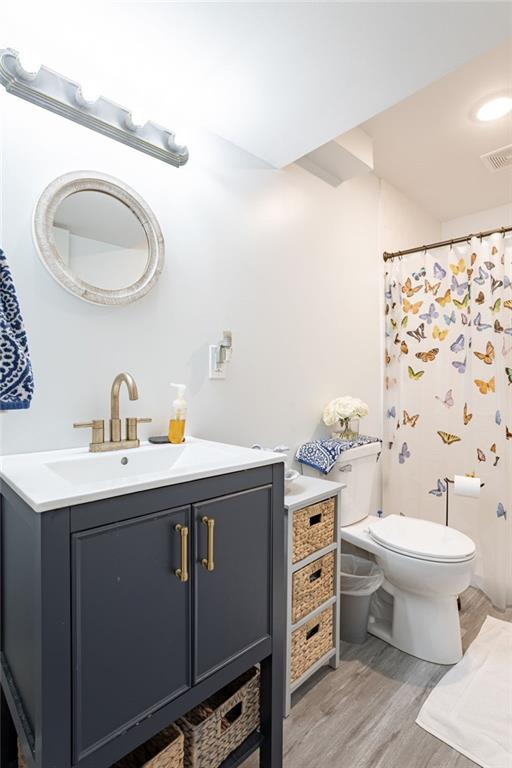 bathroom with toilet, vanity, and hardwood / wood-style flooring