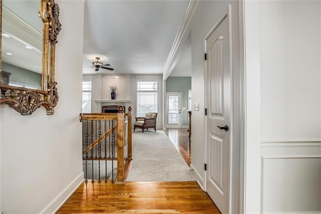 hallway with light hardwood / wood-style floors and crown molding