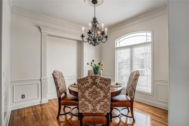 dining room featuring crown molding, wood-type flooring, and a notable chandelier