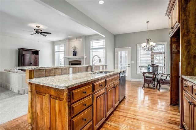 kitchen with dishwasher, sink, an island with sink, decorative light fixtures, and ceiling fan with notable chandelier