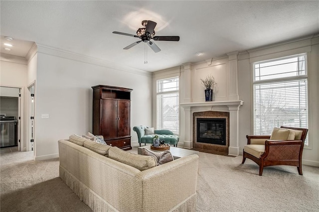 carpeted living room featuring a tiled fireplace, ceiling fan, and ornamental molding