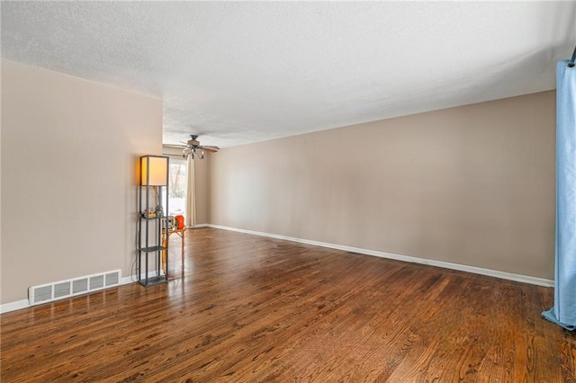 spare room featuring a textured ceiling, ceiling fan, and dark hardwood / wood-style floors