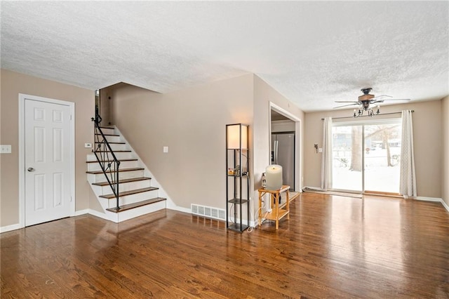 interior space with a textured ceiling, dark hardwood / wood-style floors, and ceiling fan