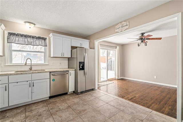 kitchen with backsplash, sink, white cabinets, and appliances with stainless steel finishes