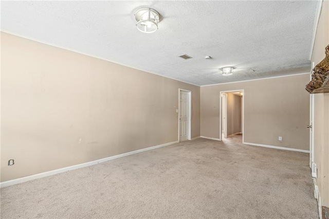 empty room featuring light colored carpet and a textured ceiling