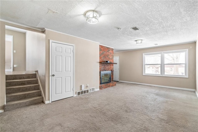 unfurnished living room featuring carpet, ornamental molding, a fireplace, and a textured ceiling