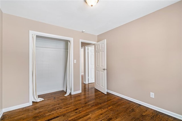 unfurnished bedroom featuring dark hardwood / wood-style flooring and a closet