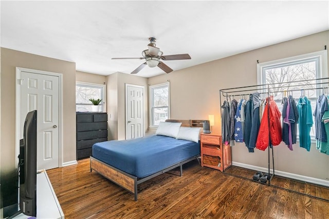 bedroom featuring multiple windows, dark hardwood / wood-style floors, and ceiling fan