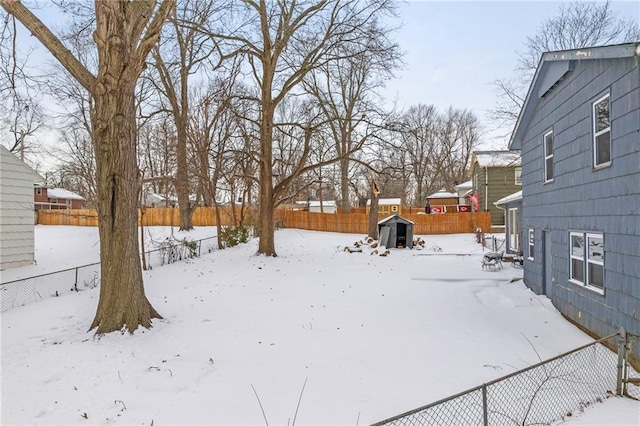 yard layered in snow featuring a storage shed