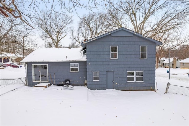 view of snow covered back of property