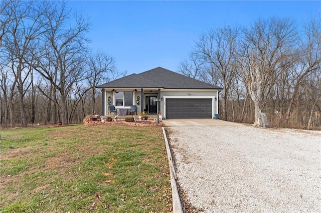 view of front of house featuring a front lawn, covered porch, and a garage