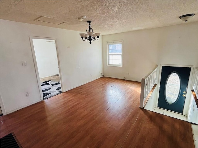 entryway with hardwood / wood-style flooring, a notable chandelier, and a textured ceiling