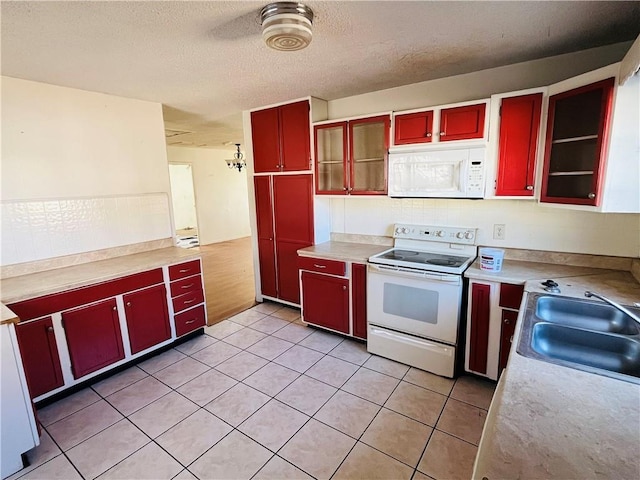 kitchen featuring light tile patterned floors, white appliances, a textured ceiling, and sink