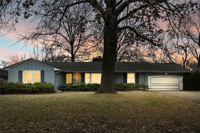 single story home with a garage and a lawn