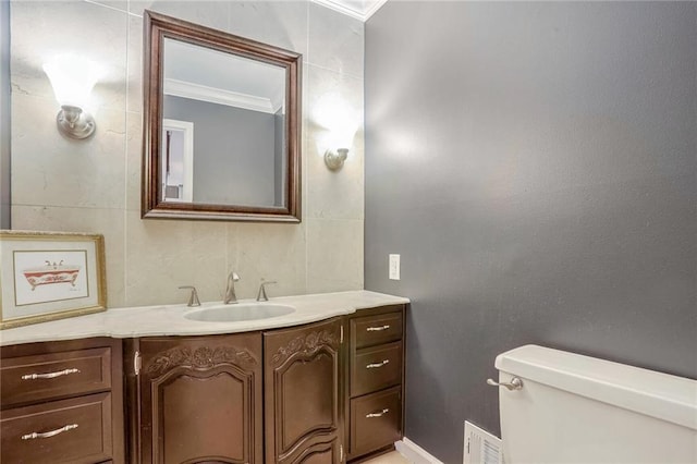 bathroom with toilet, vanity, and ornamental molding