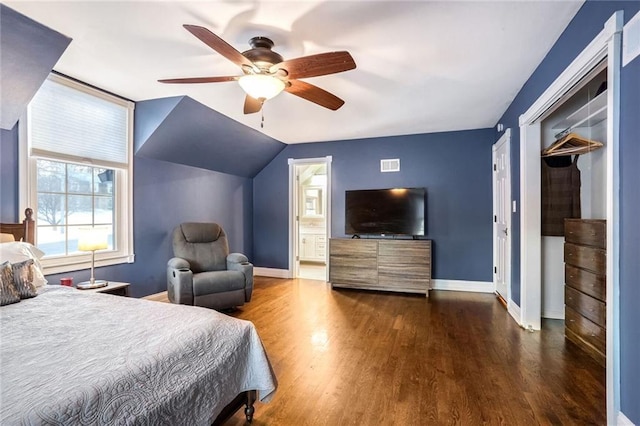 bedroom with ceiling fan, dark hardwood / wood-style floors, ensuite bathroom, vaulted ceiling, and a closet