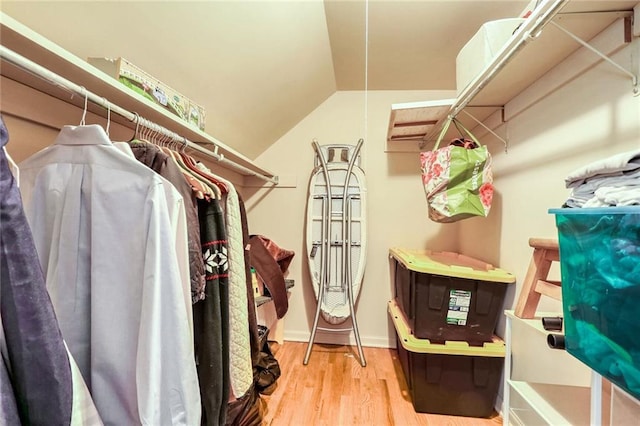 walk in closet featuring hardwood / wood-style floors and vaulted ceiling