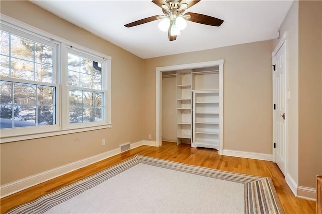 unfurnished bedroom featuring ceiling fan, a closet, and light hardwood / wood-style flooring