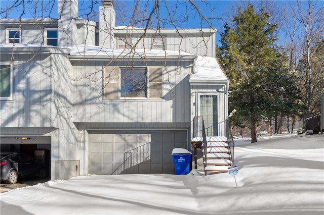 view of snow covered exterior with a garage