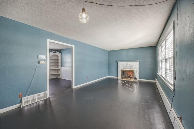 unfurnished living room with a textured ceiling and a stone fireplace