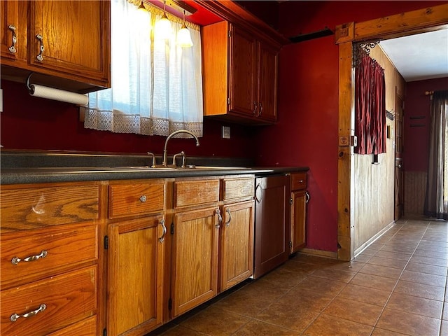 kitchen with tile patterned flooring, dishwasher, sink, and hanging light fixtures