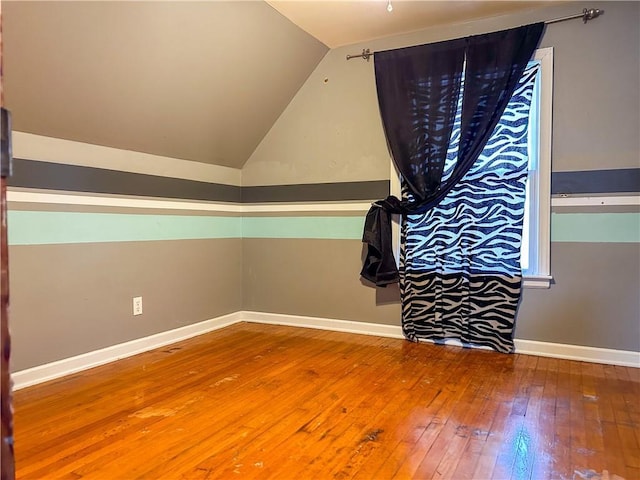 interior space featuring hardwood / wood-style flooring and vaulted ceiling