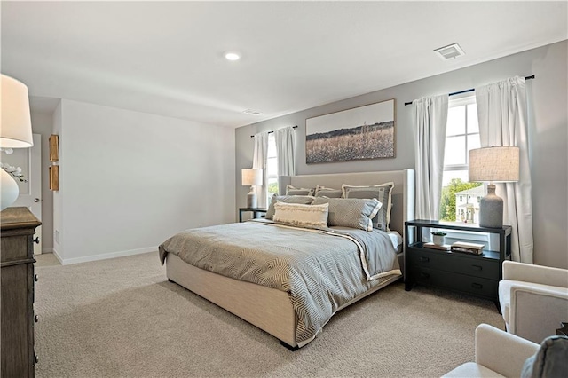 bedroom featuring baseboards, light carpet, and visible vents