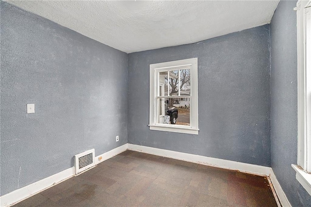 unfurnished room featuring a textured ceiling