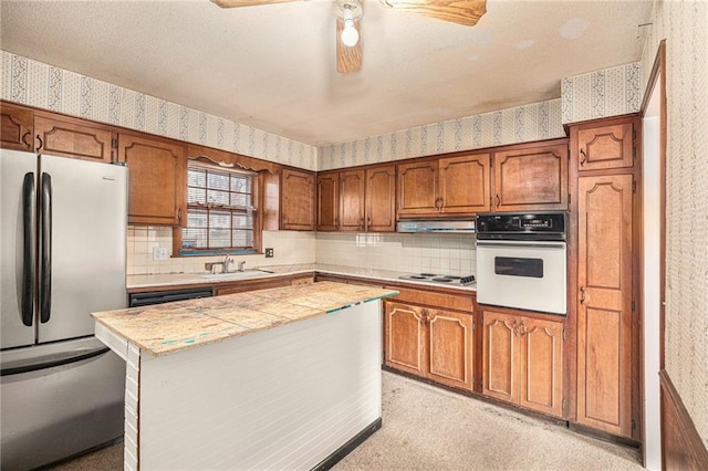 kitchen featuring decorative backsplash, a kitchen island, white appliances, and sink