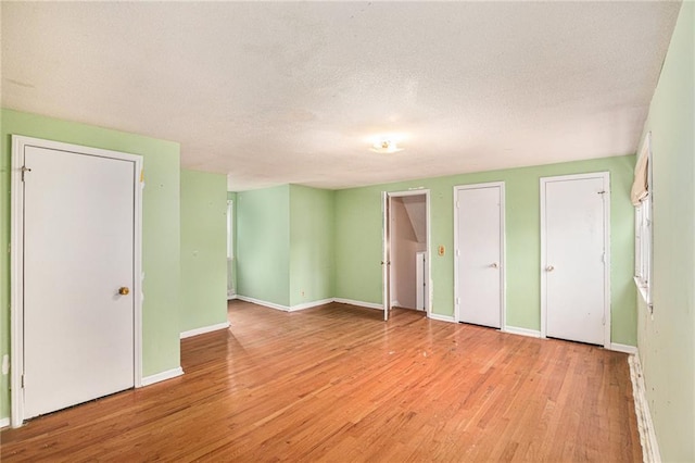 unfurnished bedroom featuring light hardwood / wood-style floors and a textured ceiling