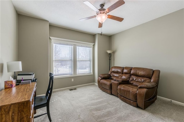 carpeted office space featuring ceiling fan