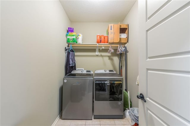 laundry area featuring washer and dryer and light tile patterned floors