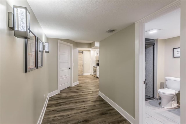 hall with dark hardwood / wood-style floors and a textured ceiling