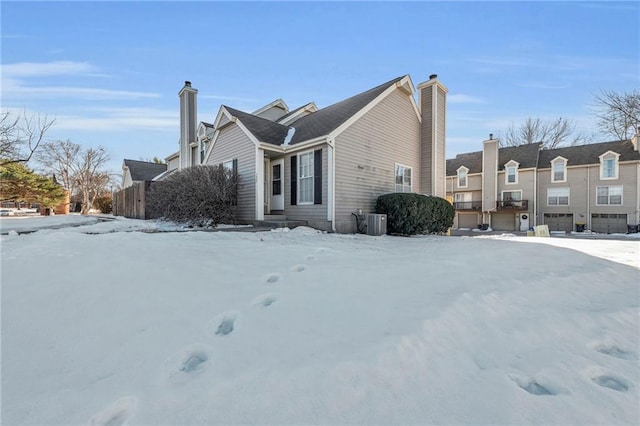 snow covered property featuring central AC