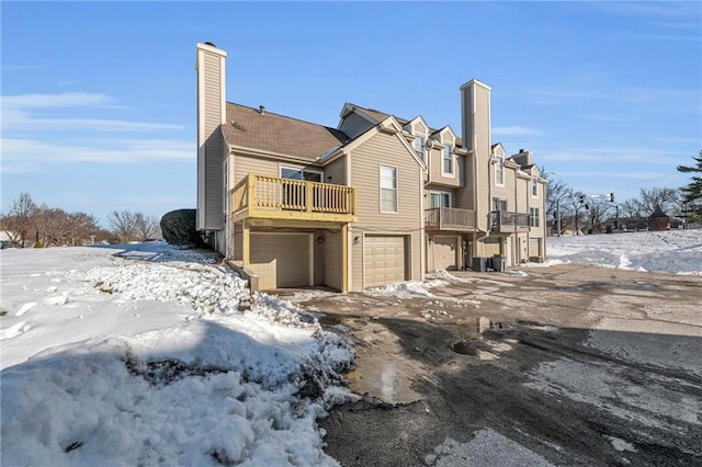 snow covered rear of property featuring a balcony