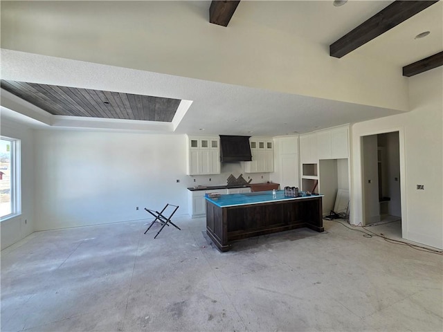 kitchen with dark brown cabinetry, beamed ceiling, white cabinetry, and a kitchen island