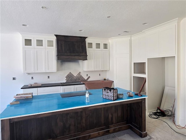 kitchen with cooktop, white cabinetry, and a textured ceiling