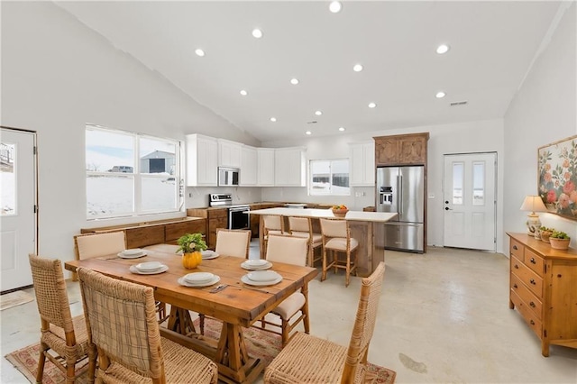 dining space featuring a wealth of natural light and high vaulted ceiling