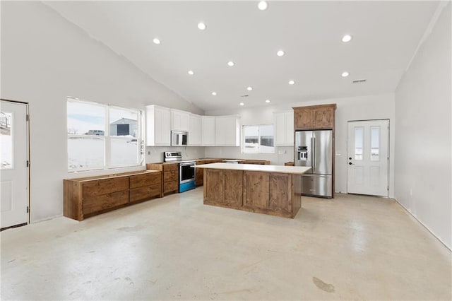 kitchen featuring appliances with stainless steel finishes, a center island, white cabinets, and plenty of natural light