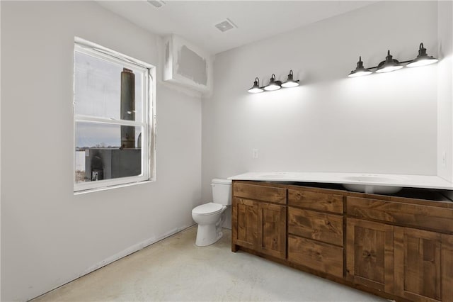 bathroom featuring vanity, toilet, and concrete floors