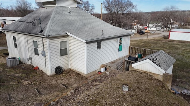 view of property exterior featuring a shingled roof and central air condition unit