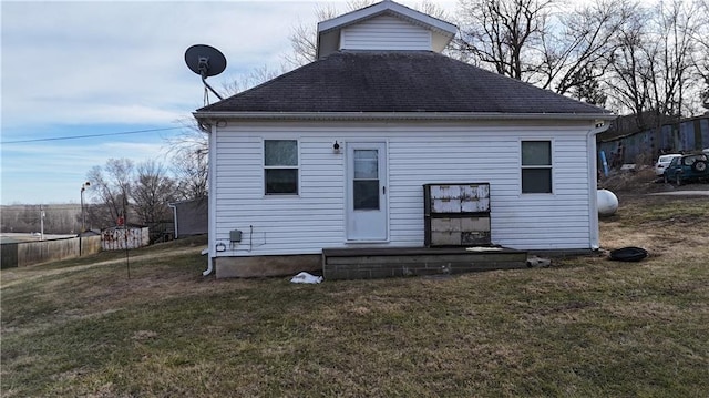 rear view of property with a yard and fence