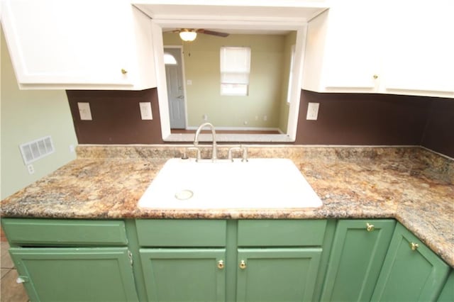 kitchen featuring ceiling fan, a sink, visible vents, white cabinets, and light countertops