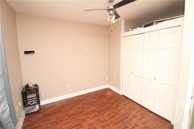 unfurnished bedroom featuring wood finished floors, a ceiling fan, and baseboards